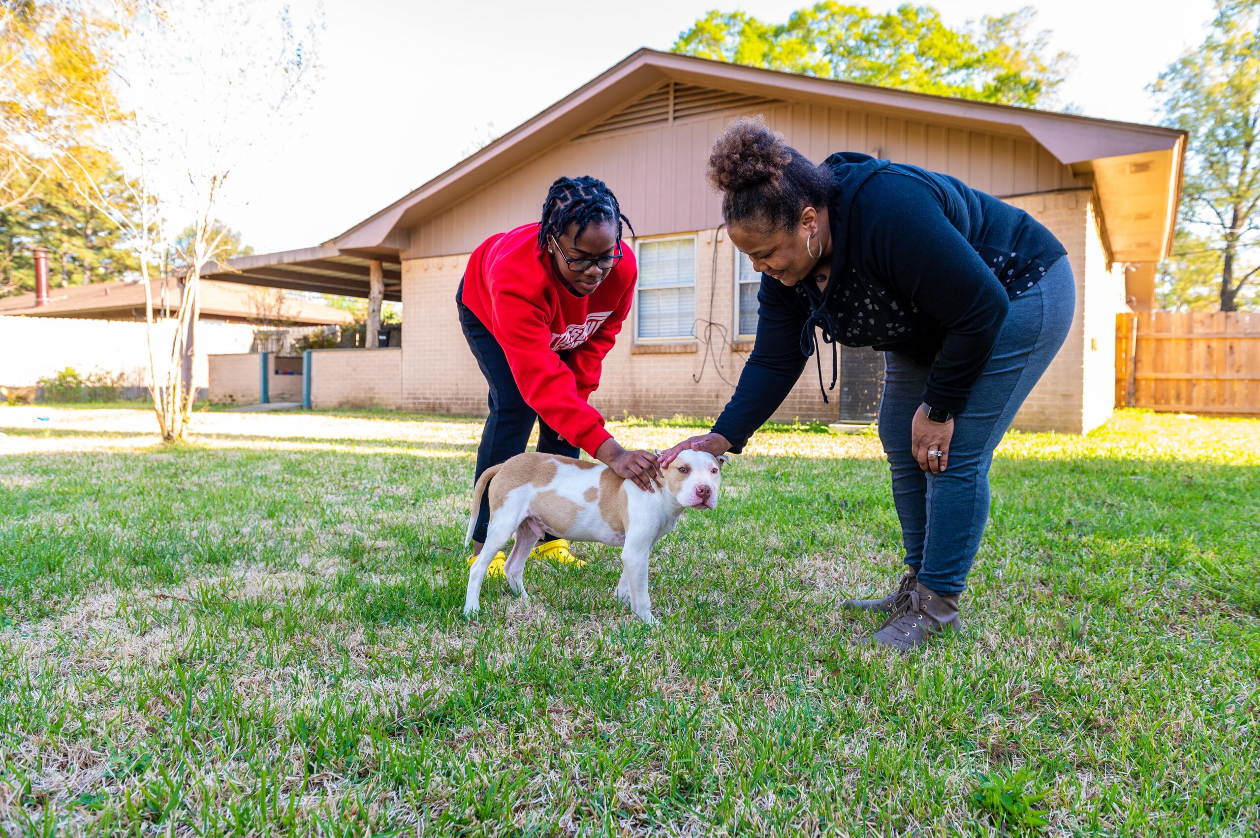 A woman of color and her daughter playing in the backyard of their newly bought home through HOPE.