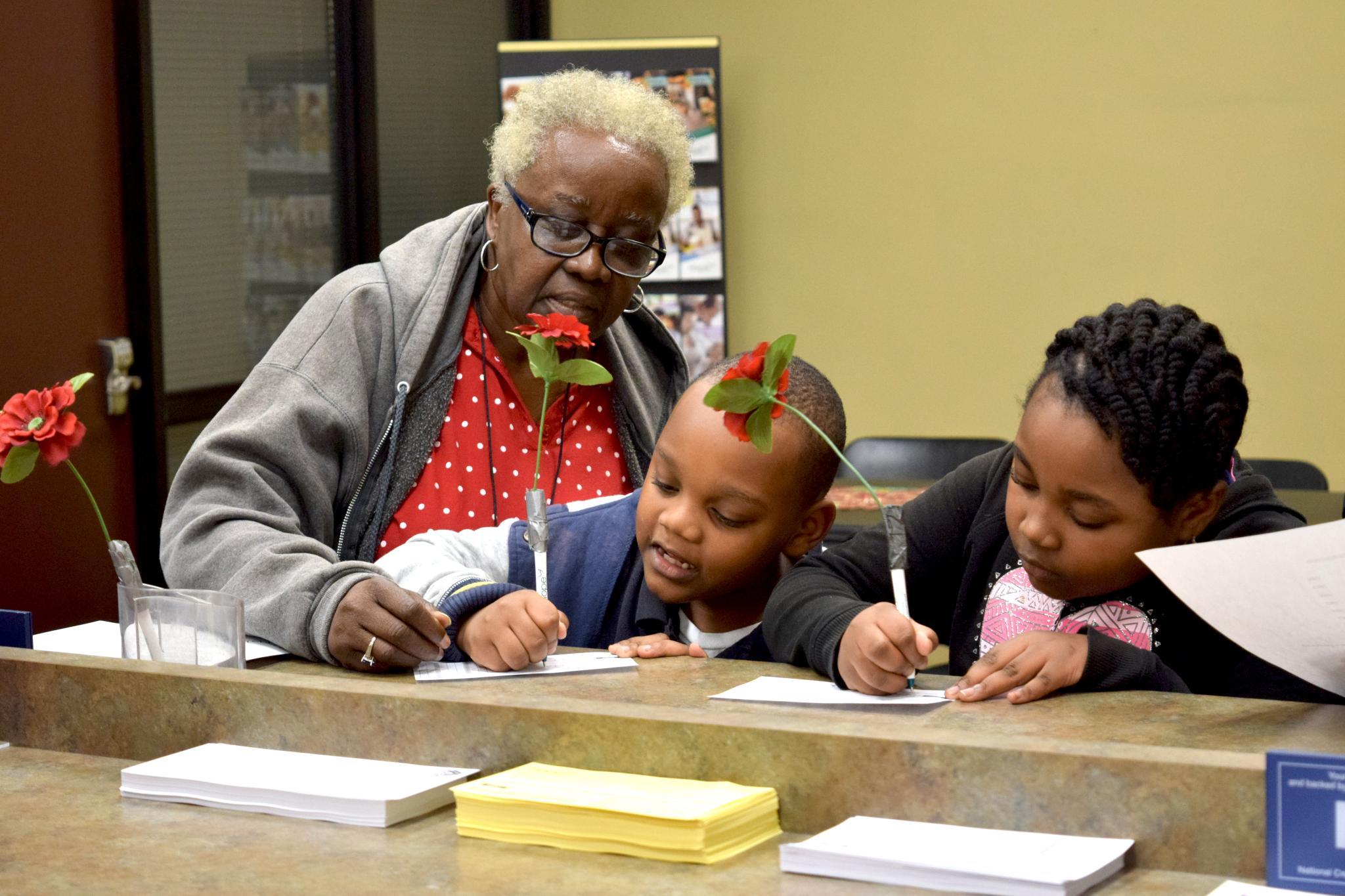 HOPE member with children interacting at the teller line in a HOPE branch in Deep South